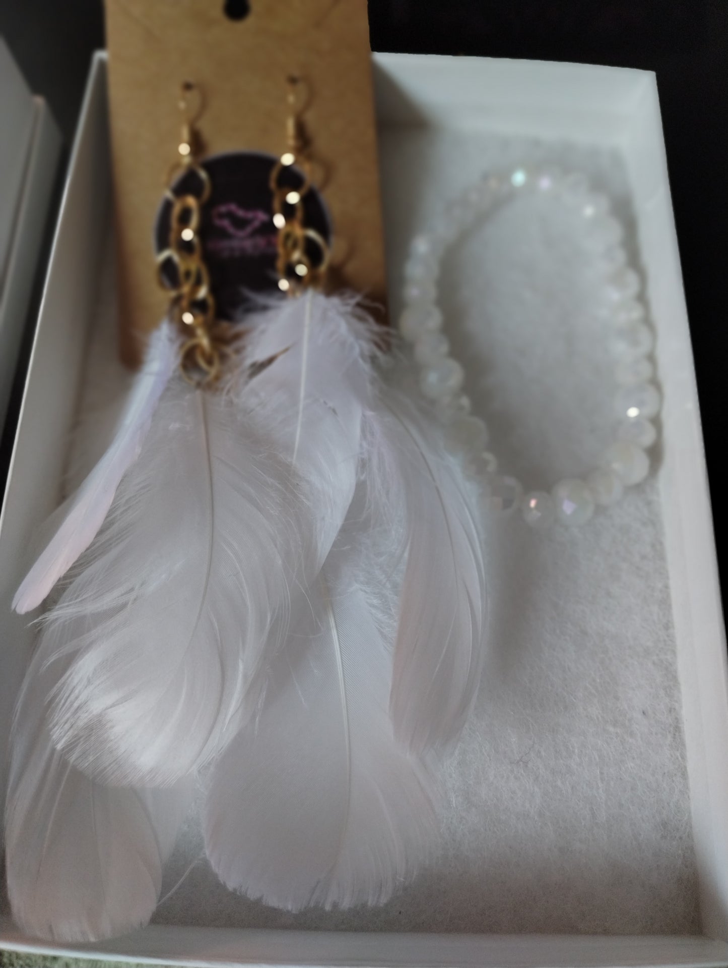 White feather earrings with white crystal beaded bracelet.